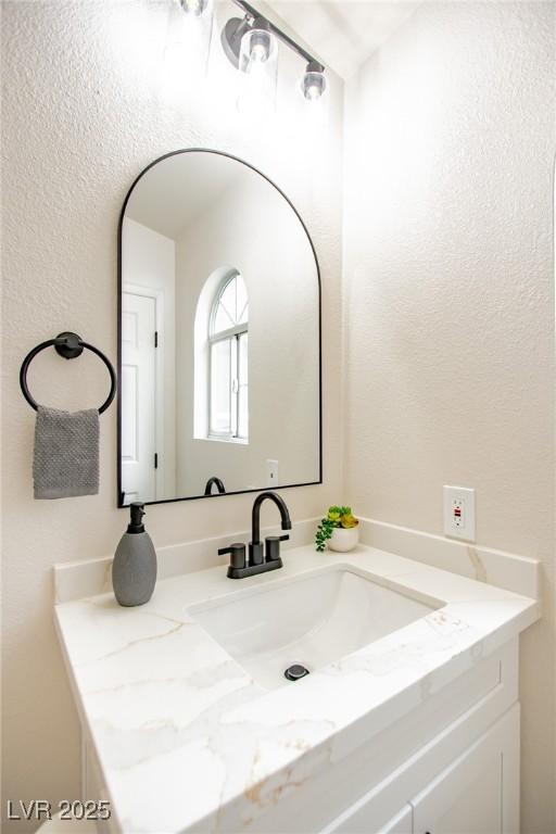 bathroom with vanity and a textured wall