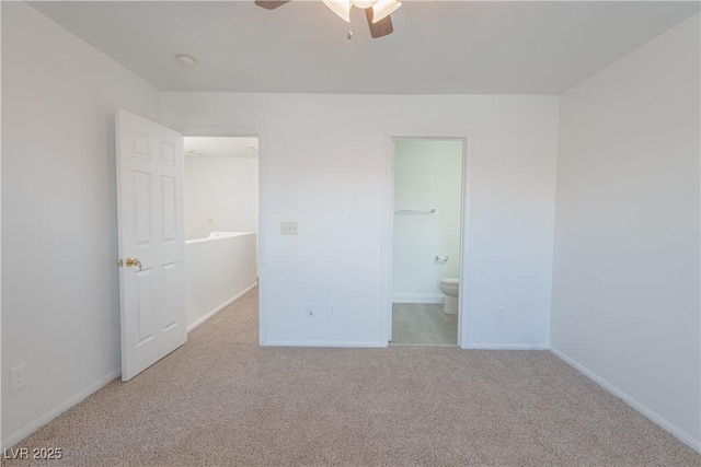 unfurnished bedroom with carpet floors, baseboards, ensuite bathroom, and a ceiling fan