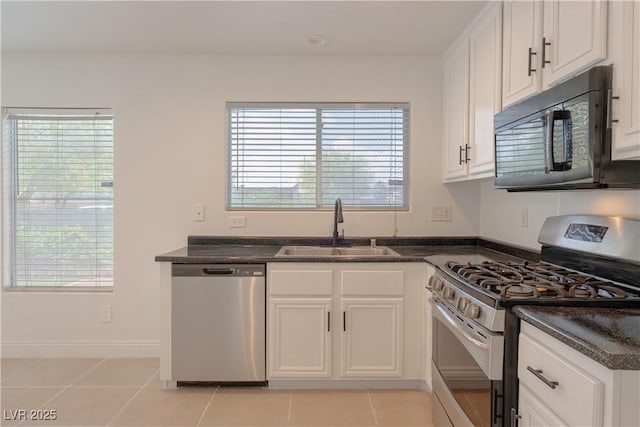 kitchen featuring appliances with stainless steel finishes, a sink, and white cabinetry