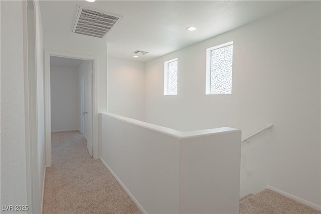 hall with carpet, an upstairs landing, baseboards, and recessed lighting