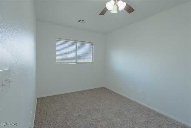 carpeted spare room featuring a ceiling fan and baseboards