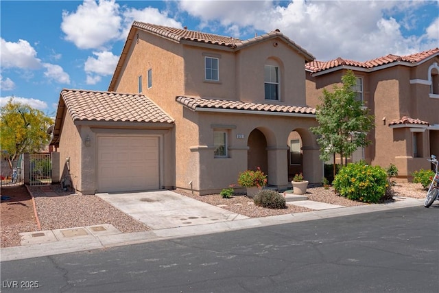 mediterranean / spanish-style house with concrete driveway, a garage, stucco siding, a tile roof, and fence
