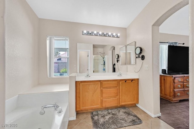 full bathroom with a garden tub, a shower stall, double vanity, and tile patterned flooring