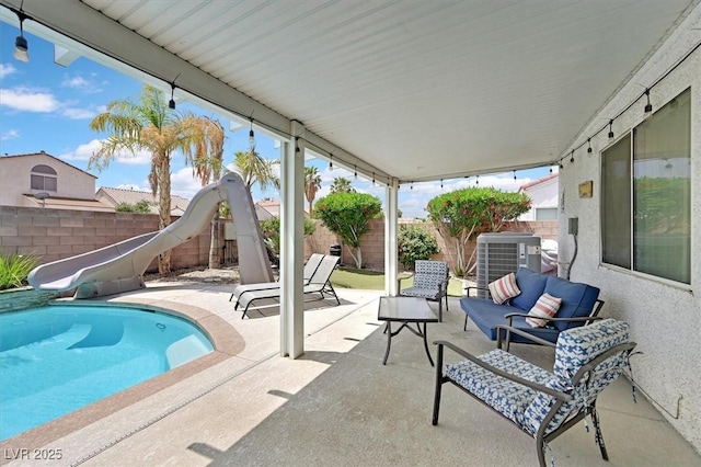 view of swimming pool featuring a water slide, cooling unit, a patio area, and a fenced backyard
