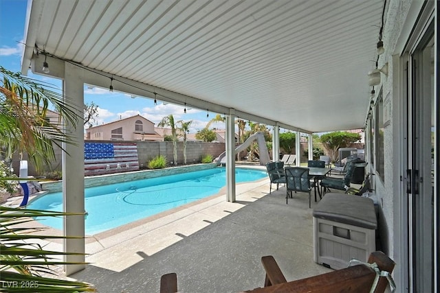 view of swimming pool with a fenced backyard, a patio area, and outdoor dining space