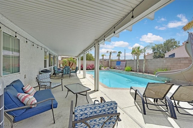 view of pool featuring a water slide, a patio, and a fenced backyard