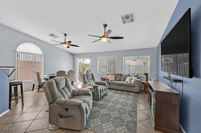 living room featuring light tile patterned floors, lofted ceiling, ceiling fan, and baseboards