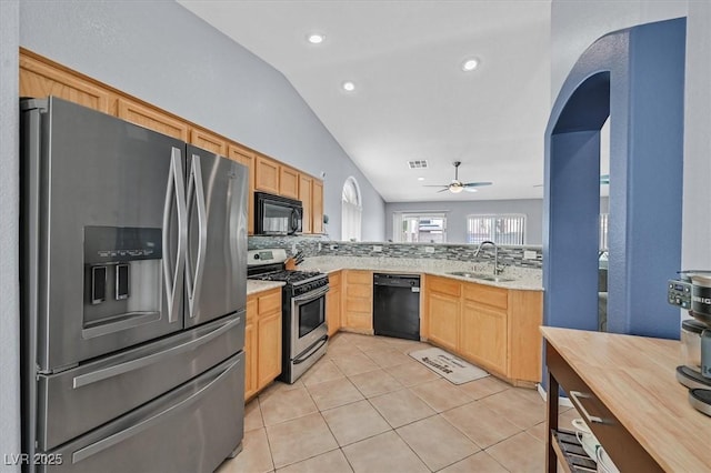 kitchen with black appliances, a sink, light brown cabinetry, vaulted ceiling, and tasteful backsplash