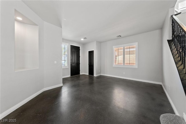 spare room featuring baseboards, recessed lighting, and stairway