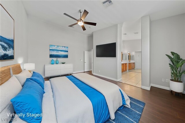 bedroom with wood finished floors, baseboards, ensuite bath, and ceiling fan