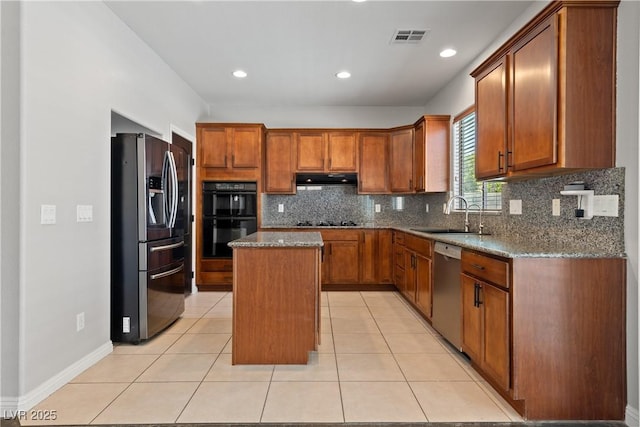 kitchen featuring black appliances, a sink, a center island, brown cabinetry, and recessed lighting