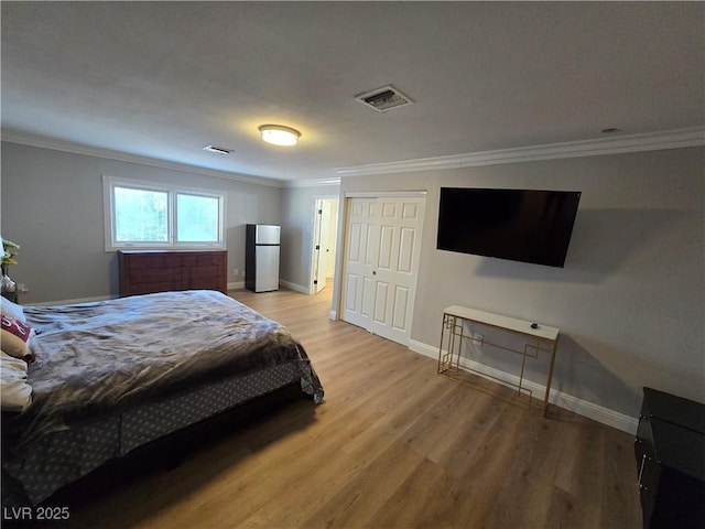 5515 Coley Ave, Las Vegas, NV 89146 - bedroom featuring freestanding refrigerator, wood finished floors, crown molding, and baseboards