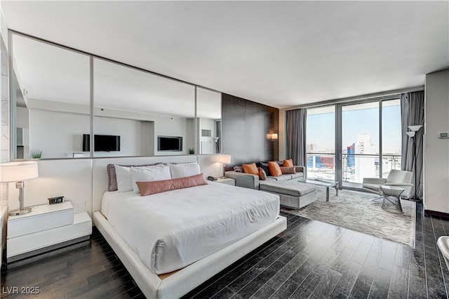 4381 W Flamingo Rd Unit 3206, Las Vegas, NV 89103 - bedroom featuring dark wood-style flooring and expansive windows