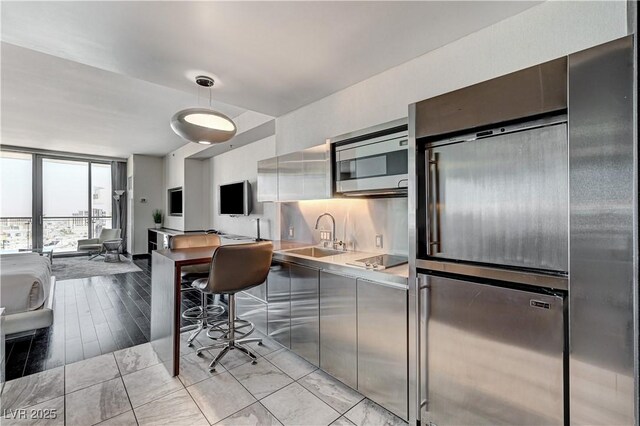4381 W Flamingo Rd Unit 3206, Las Vegas, NV 89103 - kitchen featuring a sink, built in appliances, light countertops, modern cabinets, and expansive windows