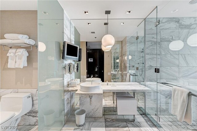 4381 W Flamingo Rd Unit 3206, Las Vegas, NV 89103 - bathroom featuring a shower stall, toilet, tile walls, and a sink