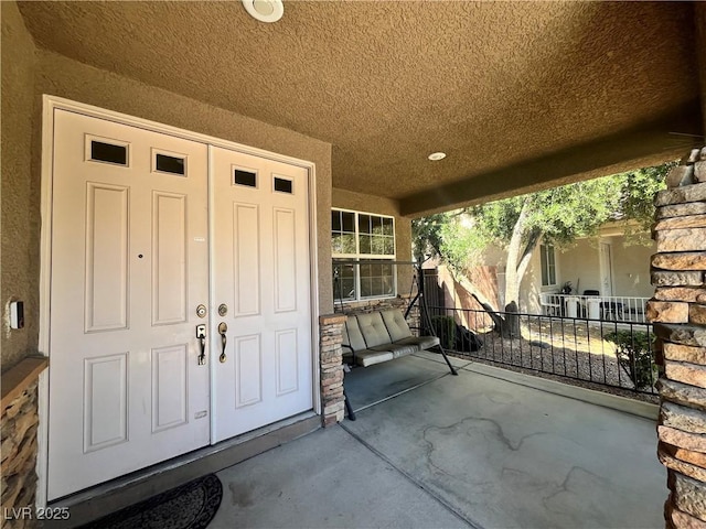 2112 Merganser Ct, North Las Vegas, NV 89084 - doorway to property with stucco siding, a porch, and stone siding