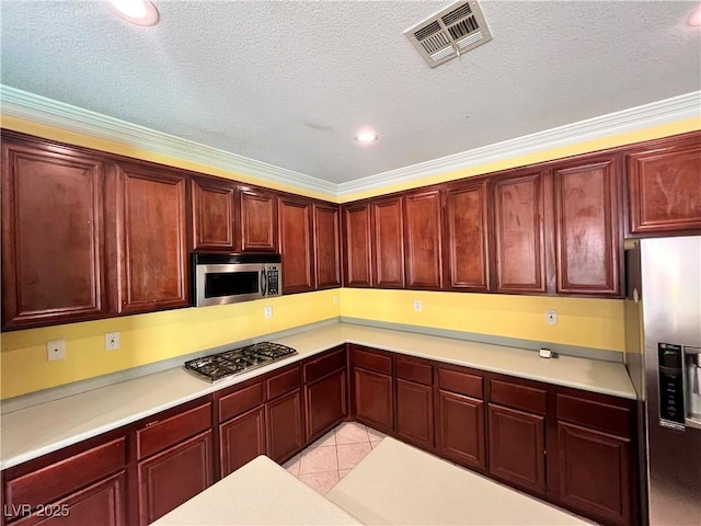 2112 Merganser Ct, North Las Vegas, NV 89084 - kitchen featuring appliances with stainless steel finishes, reddish brown cabinets, crown molding, light countertops, and recessed lighting