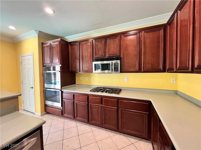 2112 Merganser Ct, North Las Vegas, NV 89084 - kitchen featuring stainless steel appliances, crown molding, light countertops, dark brown cabinets, and light tile patterned flooring