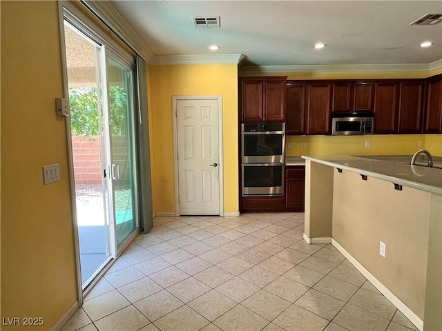 2112 Merganser Ct, North Las Vegas, NV 89084 - kitchen with stainless steel appliances, plenty of natural light, ornamental molding, light tile patterned floors, and light countertops