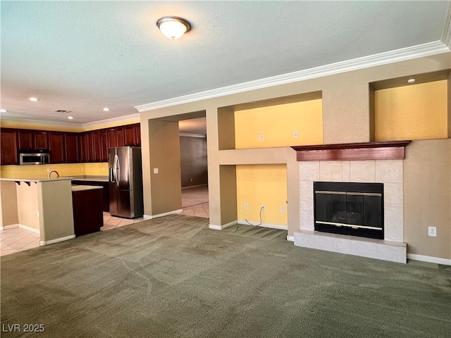2112 Merganser Ct, North Las Vegas, NV 89084 - kitchen featuring stainless steel appliances, open floor plan, ornamental molding, a fireplace, and light carpet