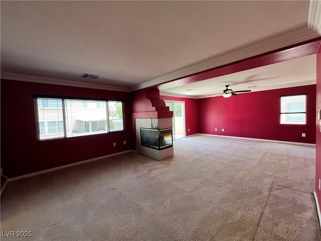 2112 Merganser Ct, North Las Vegas, NV 89084 - unfurnished living room featuring ornamental molding, light carpet, plenty of natural light, a tile fireplace, and baseboards