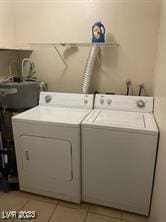 clothes washing area featuring washing machine and dryer and light tile patterned flooring