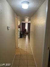 hallway with tile patterned floors and baseboards