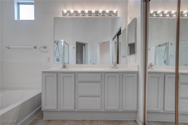 full bath with a stall shower, a bath, double vanity, and tile patterned flooring