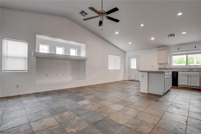 kitchen with lofted ceiling, recessed lighting, baseboards, stone tile floors, and open floor plan