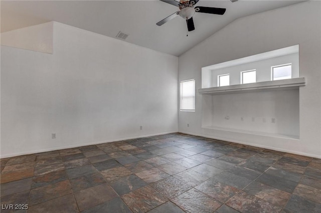 unfurnished room featuring vaulted ceiling, baseboards, ceiling fan, and stone tile flooring