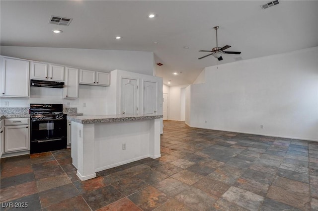 kitchen featuring black gas range, vaulted ceiling, baseboards, stone tile floors, and ceiling fan