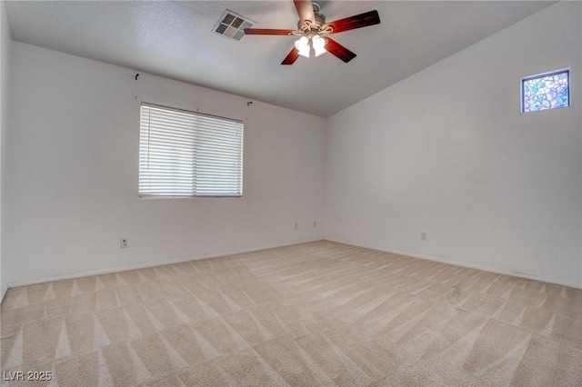 unfurnished room with plenty of natural light, light colored carpet, a ceiling fan, and lofted ceiling