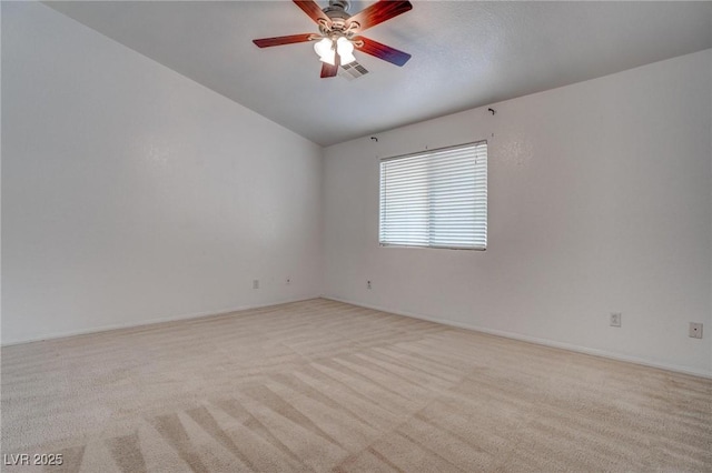 empty room featuring lofted ceiling, light carpet, a ceiling fan, and baseboards