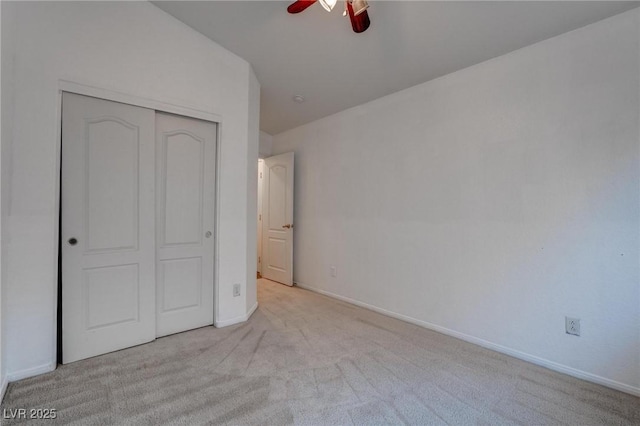unfurnished bedroom with carpet flooring, a closet, baseboards, and ceiling fan