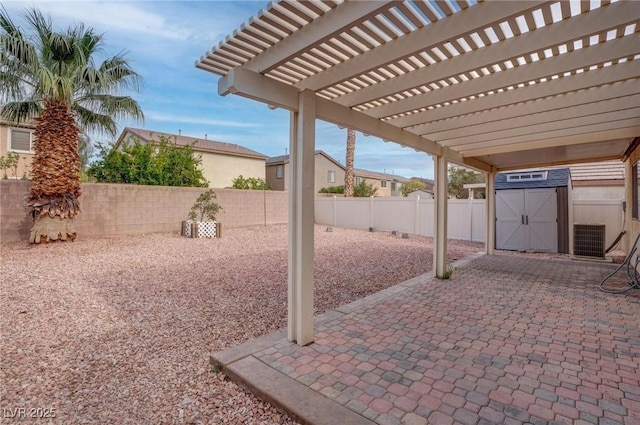 view of patio with a fenced backyard, a storage unit, an outdoor structure, and a pergola