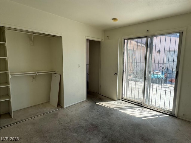 unfurnished bedroom featuring carpet, a closet, and access to exterior