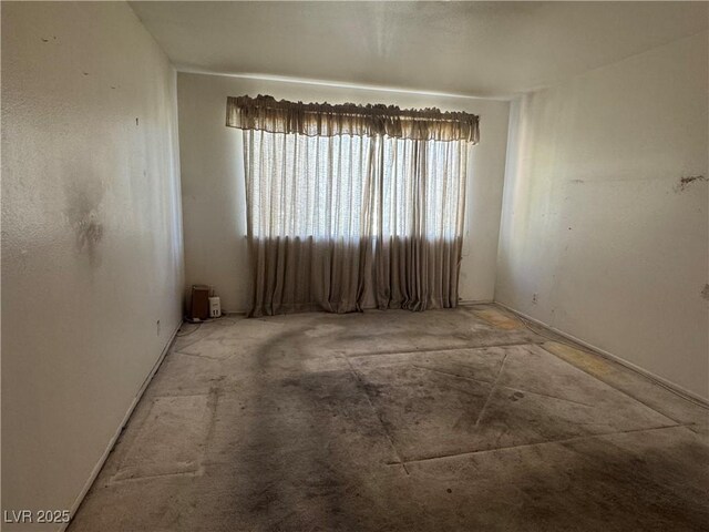 carpeted spare room featuring baseboards