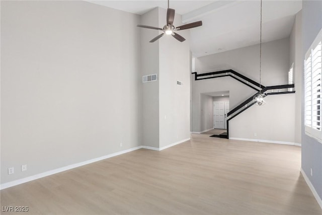 3246 Brookfield Dr, Las Vegas, NV 89120 - unfurnished living room with wood finished floors, a high ceiling, plenty of natural light, baseboards, and a ceiling fan