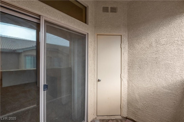 view of exterior entry with stucco siding