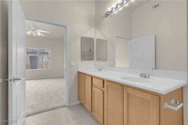 bathroom with a ceiling fan, double vanity, baseboards, and tile patterned flooring