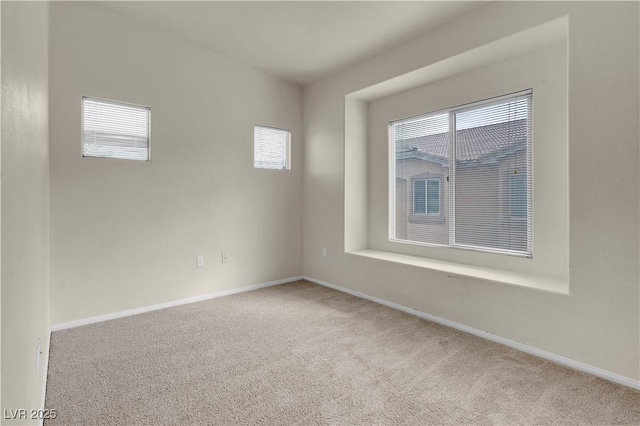spare room featuring carpet flooring and baseboards