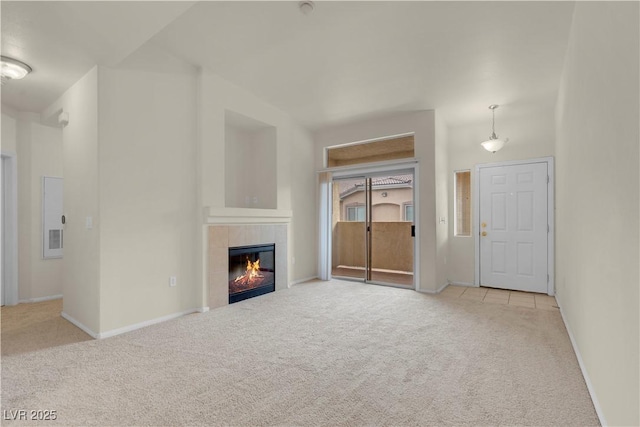 unfurnished living room featuring carpet flooring, a fireplace, and baseboards