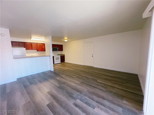 unfurnished living room with dark wood-style flooring and baseboards