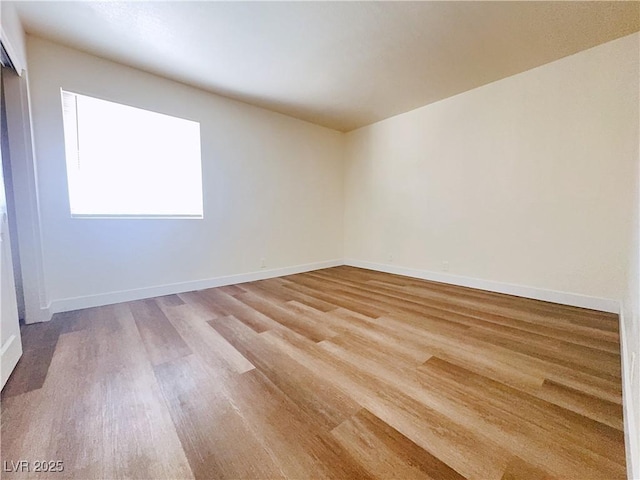unfurnished room with light wood finished floors and baseboards