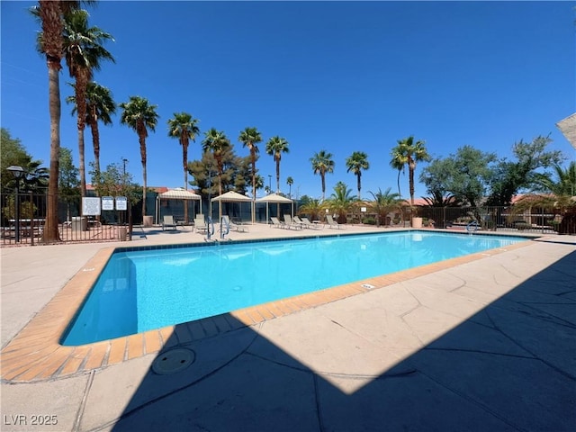 community pool with fence and a patio
