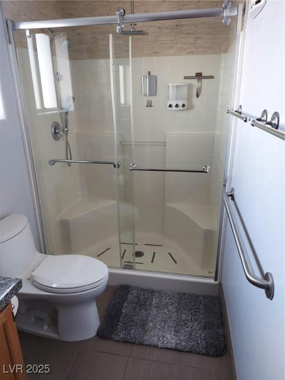 full bathroom featuring tile patterned flooring, toilet, a shower stall, and vanity