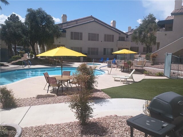 community pool featuring fence and a patio area