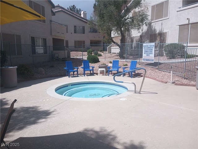 view of swimming pool featuring fence, a hot tub, and a patio