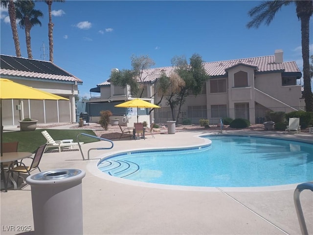 community pool featuring a patio and fence