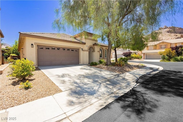 145 Austin Rose Ave, Henderson, NV 89002 - mediterranean / spanish-style home with stucco siding, driveway, a garage, and a tile roof